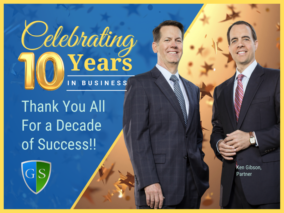 Ken Gibson and John Singleton on a banner that reads "Celebrating 10 Years. Thank you all for a decade of success."